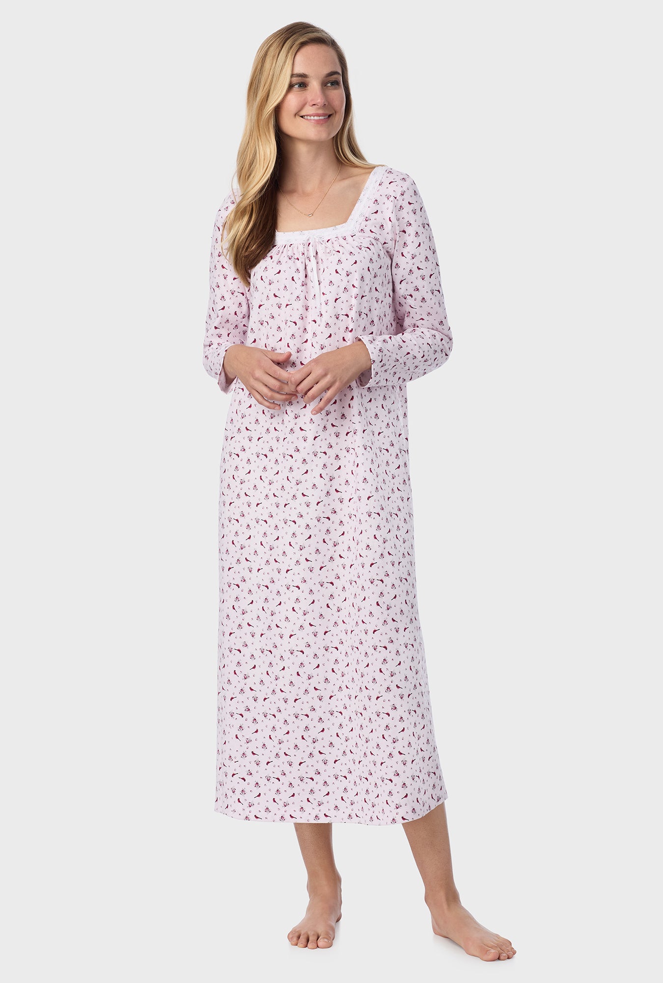 A lady wearing pink long sleeve cotton ballet nightgown with mini cardinal print.