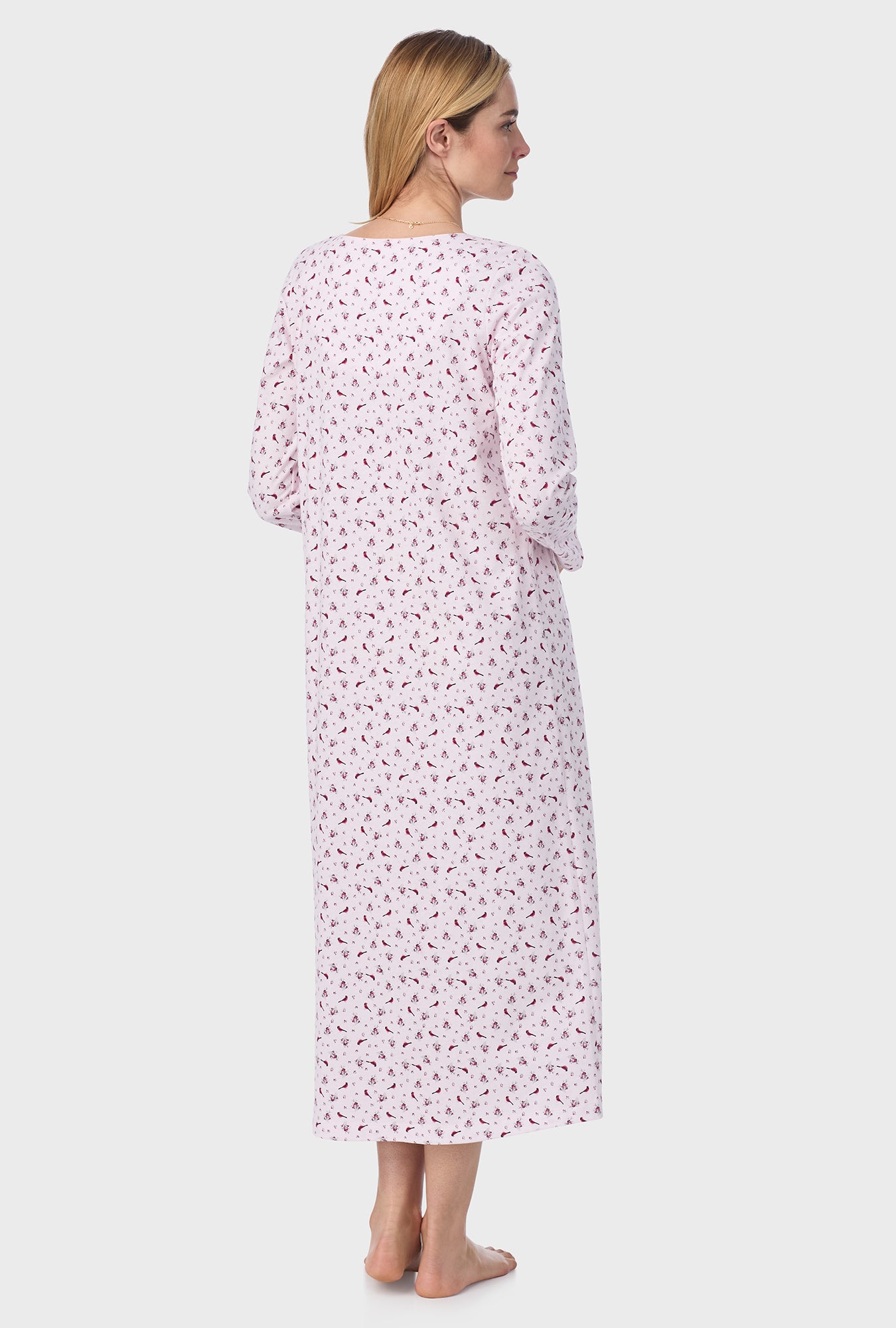 A lady wearing pink long sleeve cotton ballet nightgown with mini cardinal print.