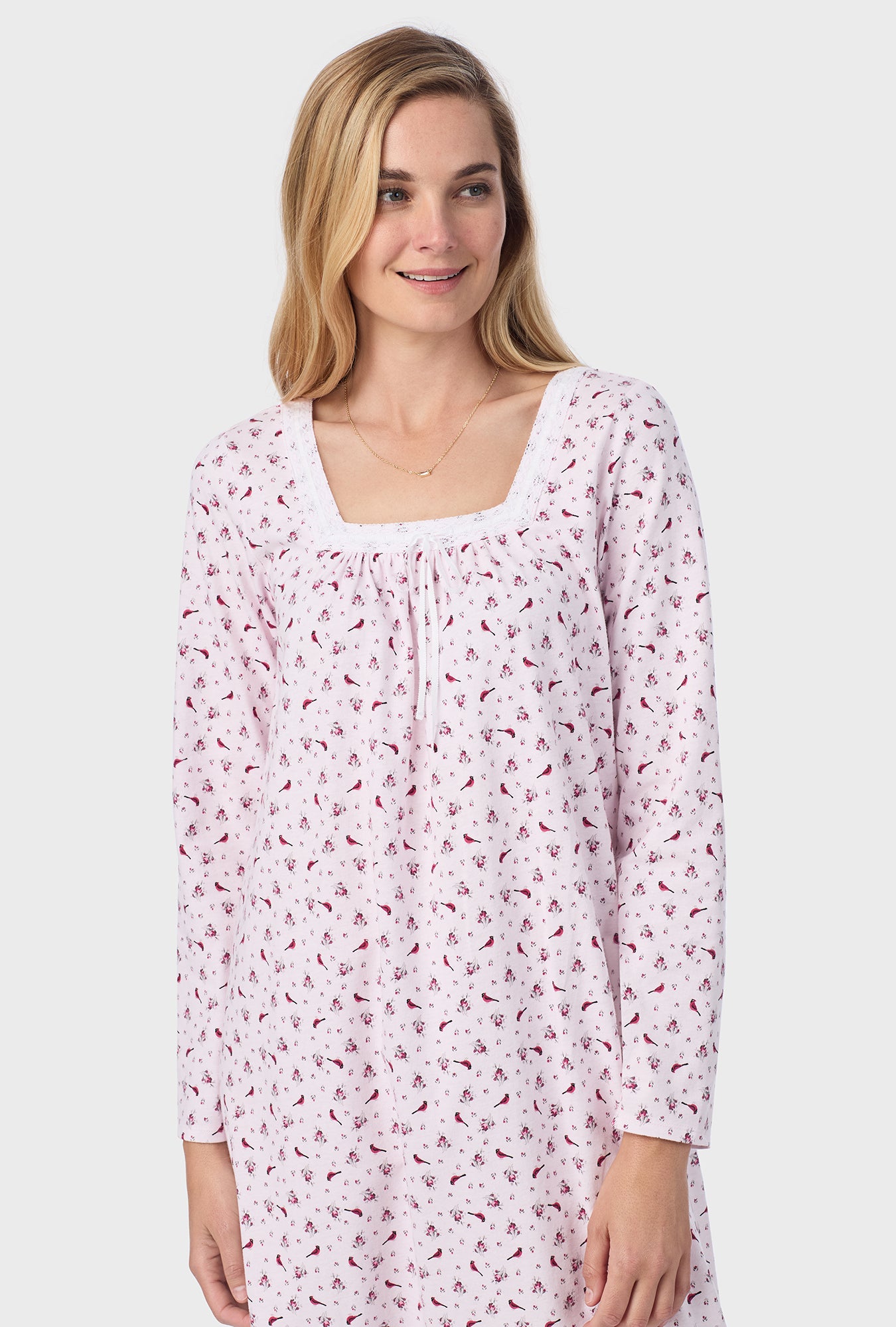 A lady wearing pink long sleeve cotton ballet nightgown with mini cardinal print.