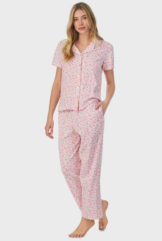 A lady wearing pink short sleeve long pajama set with spring disty print.