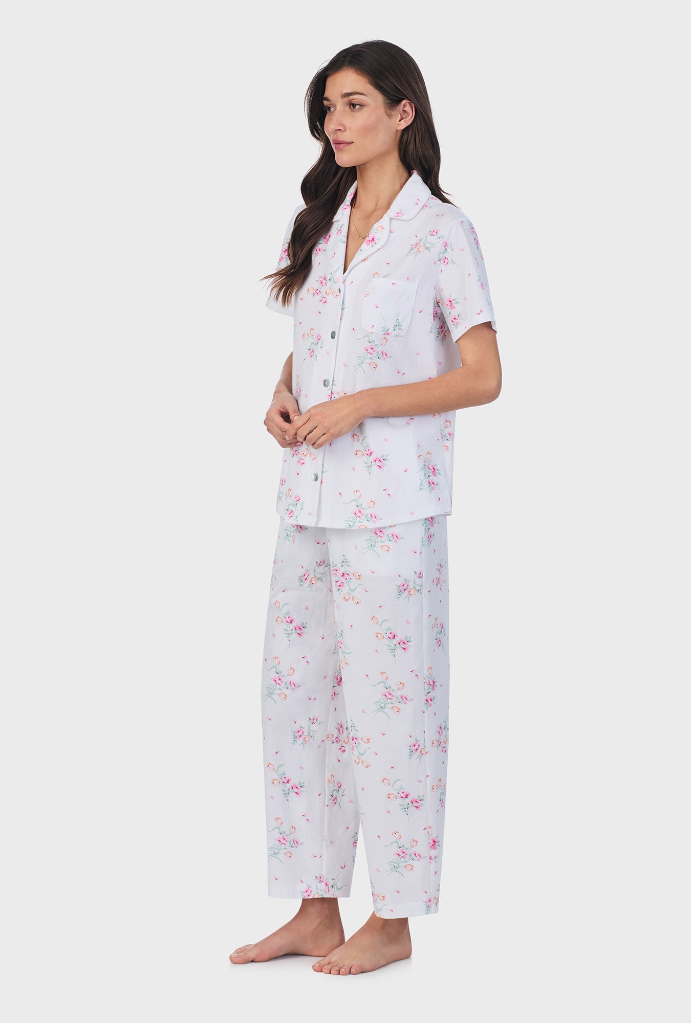 A lady wearing pink short sleeve cotton capri pajama set with floral bouquet print.