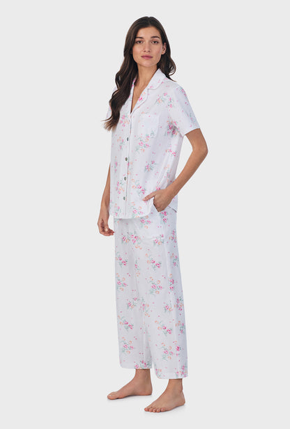 A lady wearing pink short sleeve cotton capri pajama set with floral bouquet print.