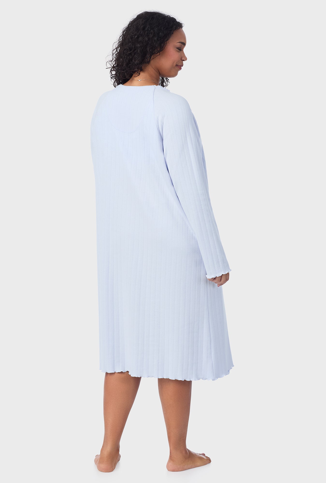 A lady wearing blue long sleeve cotton pointelle waltz plus nightgown.