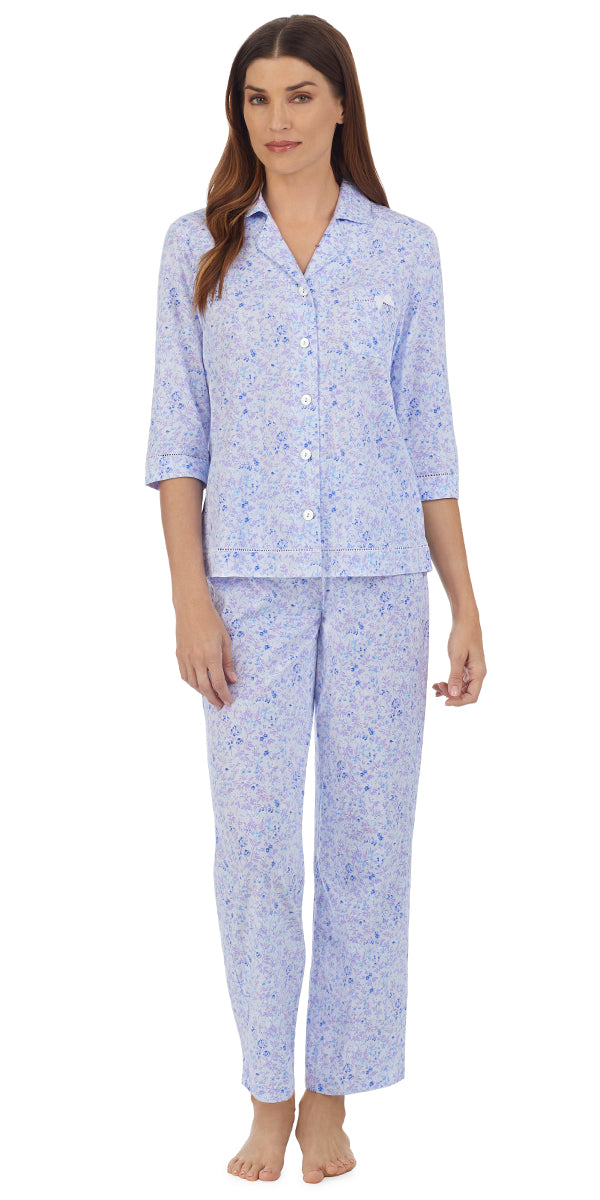 A lady wearing a quarter sleeve pajama set with blue wild floral pattern.