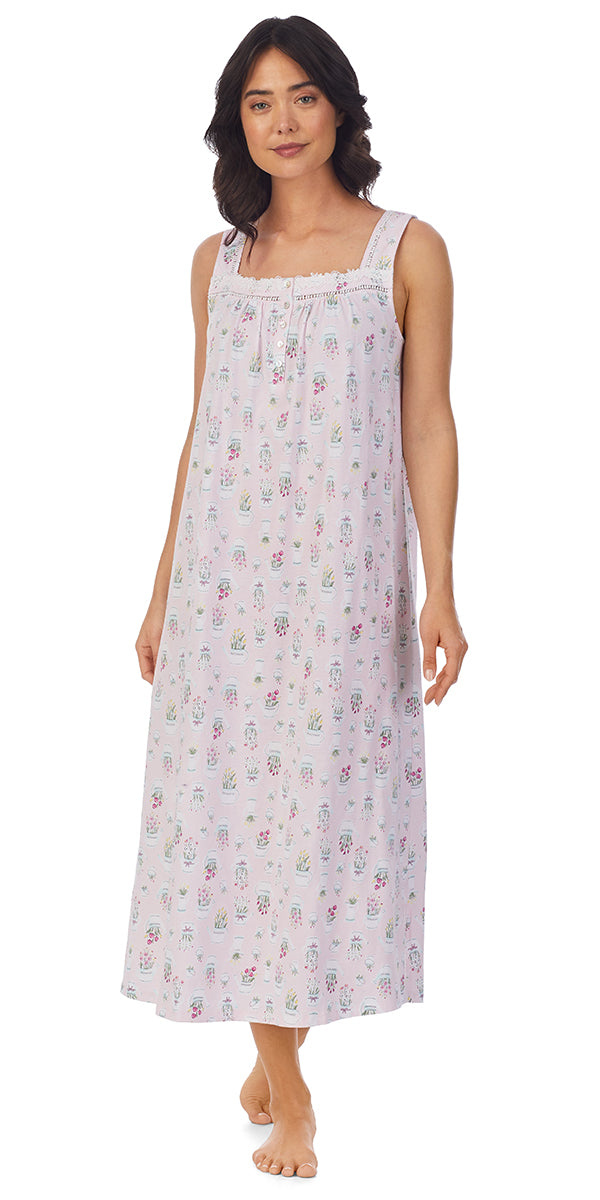 A lady wearing a pink sleeveless long nightgown with flower pots pattern.