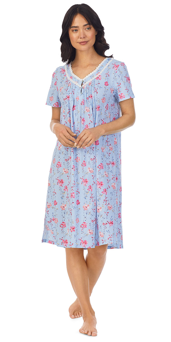 A lady wearing a blue short sleeve waltz nightgown with pink floral pattern.
