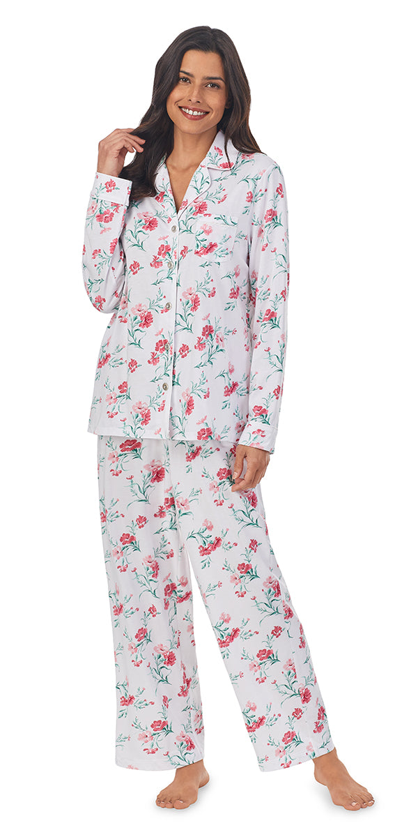 A lady wearing a long sleeve pajama set with pink carnations pattern.