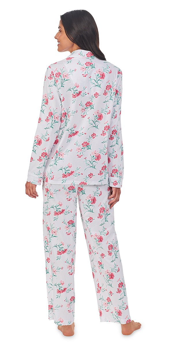 A lady wearing a long sleeve pajama set with pink carnations pattern.
